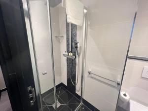 a bathroom with a shower with a glass door at Great St Helen Hotel in London