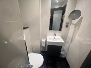 a small bathroom with a toilet and a sink at Great St Helen Hotel in London