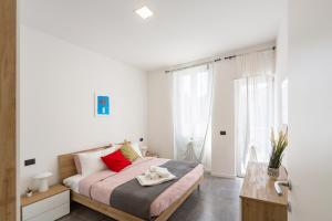 a bedroom with a large bed with red pillows at KHL APARTMENTS - SanSiro, Milano in Milan