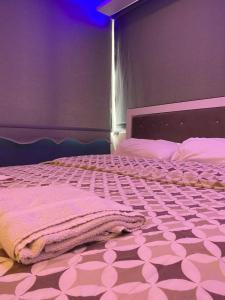 1 dormitorio con 1 cama y suelo de color rosa y blanco en Daily, en Konak