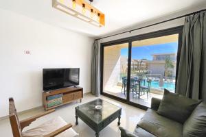sala de estar con sofá y TV en Refreshed & Uplifted 2 BDR G Cribs, en Hurghada
