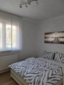 a zebra print bed in a bedroom with a window at Apartman Nika Siget in Zagreb