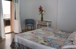 a bedroom with a bed and a table and a vase with flowers at Hotel Santiago in Milano Marittima