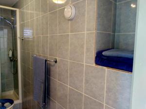 ein Bad mit einer Dusche und einem blauen Handtuch in der Unterkunft Villa Grande Vista - Lovely Apartment with Private spacious lush mediterranean patio and Sea view in Trogir
