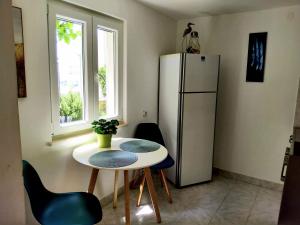 eine kleine Küche mit Tisch und Kühlschrank in der Unterkunft Villa Grande Vista - Lovely Apartment with Private spacious lush mediterranean patio and Sea view in Trogir