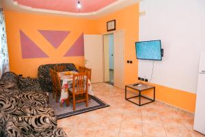 een woonkamer met een tafel en een televisie bij Aldesa Apartments in Golem