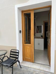 une porte en bois avec une table et une chaise dans l'établissement Lagom House, à Panagia