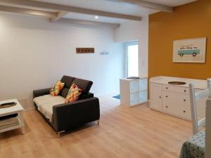 ein Wohnzimmer mit einem Sofa und einer Kommode in der Unterkunft Maison centre bourg, 6 pers, 5 minutes de la plage in Plomeur