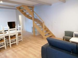 ein Wohnzimmer mit einer Treppe und einer Couch in der Unterkunft Maison centre bourg, 6 pers, 5 minutes de la plage in Plomeur