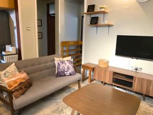 uma sala de estar com um sofá e uma televisão de ecrã plano em Tulivu House -2bedroom vacation home close to the beach em Dar es Salaam