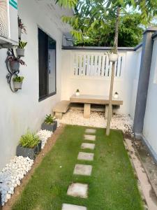 a garden with a bench in the back of a house at Tulivu House -2bedroom vacation home close to the beach in Dar es Salaam