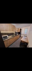 a kitchen with wooden cabinets and a wooden table at Happy Rental Apartments 1 in Craiova