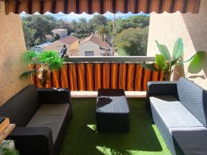 a balcony with two couches and a fence at Appartement climatisé design au cœur de St-Aygulf à 200 metres la mer in Saint-Aygulf +3 photos