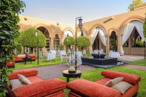 a courtyard with couches and a fountain with tables and chairs at Barceló Palmeraie in Marrakesh