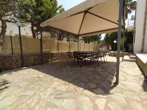 a table and chairs under an umbrella on a patio at SanVitoTour- Residence Il Baglio in San Vito lo Capo