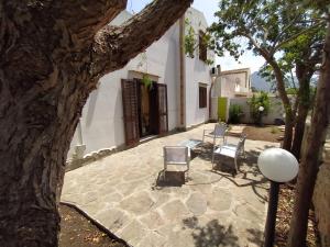 a patio with two chairs and a table at SanVitoTour- Residence Il Baglio in San Vito lo Capo