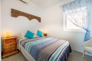 a bedroom with a bed and a chair and a window at Villa Florimar in Talamanca