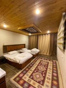 two beds in a room with a rug on the floor at Full moon camp in Disah