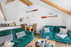 ein Wohnzimmer mit 2 grünen Sofas und einem Tisch in der Unterkunft White Star, Brixham in Brixham