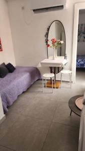 a room with a bed and a table and a mirror at Ofir, nice small unit, 123Eilat in Eilat