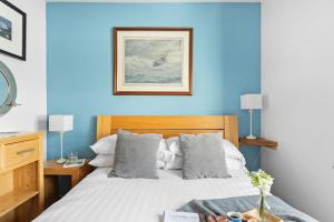 a bedroom with a bed with a blue wall at White Star, Brixham in Brixham