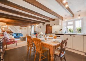 a kitchen and living room with a wooden table and chairs at 4 Zoar Cottage in Marytavy