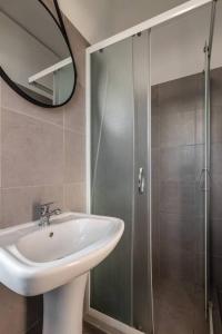 y baño con lavabo y ducha con espejo. en Seaview-City-Ladadika-Apartment en Tesalónica