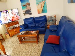 un soggiorno con divano blu e tavolo di Chalet La Alberca a Chiclana de la Frontera