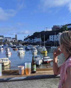 uma mulher tirando uma foto de uma marina com barcos em Historic school room em Helston