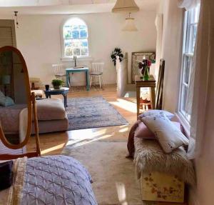 uma sala de estar com um sofá e uma mesa em Historic school room em Helston