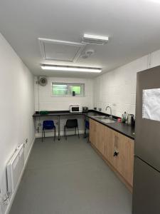 - une cuisine avec un comptoir et 2 chaises dans l'établissement Ghyll Head Hive Pod Village & Accessible Bungalow, à Winster
