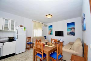 een keuken en een woonkamer met een tafel en een bank bij Chalet La Alberca in Chiclana de la Frontera