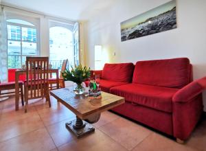 巴貝的住宿－Haus Meeresblick - Ferienwohnung Strandnah A 1.07 (Ref. 128675)，客厅配有红色的沙发和桌子