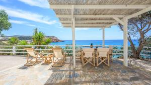 une terrasse avec une table et des chaises et l'océan dans l'établissement Giourgas Studios & Apartments, à Provatas