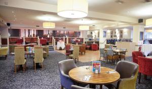 a dining room with tables and chairs and a lobby at Farmhouse Innlodge by Greene King Inns in Portsmouth