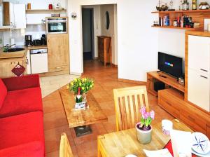 a living room with a red couch and a table at Haus Meeresblick - Ferienwohnung Strandnah A 1.07 (Ref. 128675) in Baabe