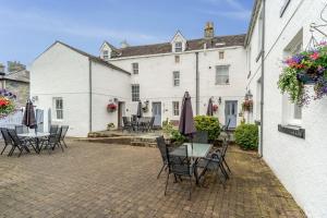 um pátio com mesas e cadeiras em frente a um edifício em Bridge House Apartment 2 em Keswick