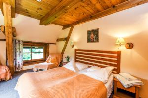 a bedroom with a bed and a chair in it at Klumpes Malunas in Vosbutai +34 photos