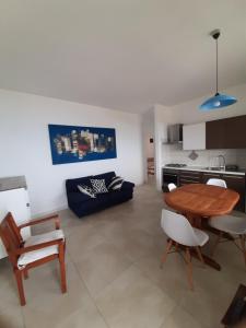a kitchen and a living room with a table and chairs at Arcomagno Guest House in San Nicola Arcella