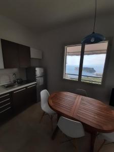 a kitchen with a wooden table and chairs and a window at Arcomagno Guest House in San Nicola Arcella