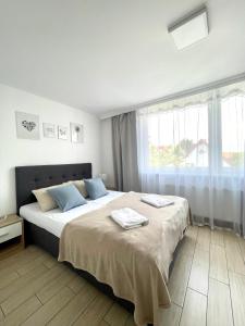 - une chambre avec un grand lit et 2 serviettes dans l'établissement Pokoje Gościnne i Apartamenty Ula, à Ustronie Morskie