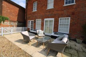 a patio with chairs and tables and a brick building at Sterling House @ Short Stays in Basingstoke