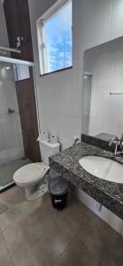 a bathroom with a toilet and a sink at Pousada Viva Mar in Saquarema