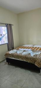 a leopard print bed in a room with a window at Pousada Viva Mar in Saquarema