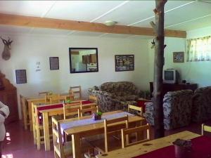 a living room filled with wooden tables and chairs at Joalani Guest Farm in Murraysburg