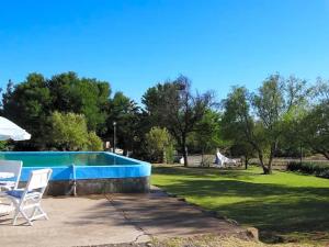 a swimming pool in a yard with two lawn chairs at Joalani Guest Farm in Murraysburg