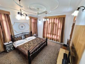 a bedroom with a bed and a television in it at Taha Inn Home comfort in Srinagar