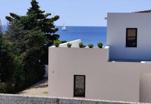 ein weißes Haus mit dem Ozean im Hintergrund in der Unterkunft Casita Vista Mar Duplex - Son Xoriguer in Son Xoriguer