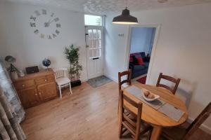 a dining room with a table and a clock on the wall at Entire House With Garden & Parking Nr Ashford Int in Ashford