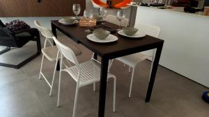 una mesa negra con sillas blancas y copas de vino. en Apartment with two Suites in the Center of Malaga, en Málaga